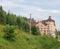 Modern apartment building on slope of forested mountains.