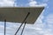 Modern architectural concrete roof on steel pylons with blue and cloudy sky behind