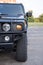 Modern armored military truck - headlight, wheel part of the car. Front view.