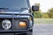 Modern armored military truck - headlight, wheel part of the car. Front view.