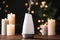Modern aroma humidifier with candles on table against blurred lights, space for text