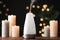 Modern aroma humidifier with candles on wooden table against blurred lights, space for