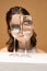 Modern art photography. Beautiful girl& x27;s face through wine glasses. Object distortion, optical illusion