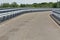 Modern asphalt road with metal fences and walkway closeup