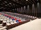 Modern auditorium, cinema hall or movie theater with rows of red, blue, black, gray or grey and white seats or chairs