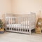 Modern baby room interior with a cozy classic crib with some decorative accessories on sides