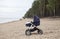 Modern baby stroller standing on empty sandy beach, side view