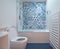 Modern bathroom with bath, toilet, niche in wall and basin unit, blue rubber floor and blue and white patchwork tiles