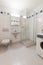 Modern bathroom in an empty and refurbished apartment with sink shower and washing machine and toilet