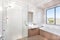 Modern bathroom with a faucet, water tub and a dark brown floor