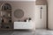 Modern bathroom interior with beige and white walls, shower area, basin with mirror, shelf and grey concrete floor.