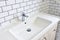 Modern bathroom Interior with design washbasin on a background of white ceramic tiles. Faucet for water at the white wall