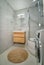 Modern bathroom interior with shower cabin and wooden washbasin cabinet