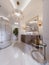 Modern bathroom with vanity and a mirror in a gold frame with sconces on the wall, a low table with decor, shower and a