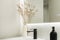 Modern bathroom with white glass countertop, black taps,