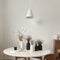 Modern beige ceramic vases with dry grass branches on white table near a black white wall backdrop. Copy space.Minimal Scandinavia