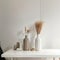 Modern beige ceramic vases with dry grass branches on white table near a black white wall backdrop. Copy space.Minimal Scandinavia