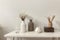 Modern beige ceramic vases with dry grass branches on white table near a black white wall backdrop. Copy space.Minimal Scandinavia