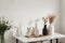 Modern beige ceramic vases with dry grass branches on white table near a black white wall backdrop. Copy space.Minimal Scandinavia