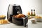 Modern black air fryer with roasted chicken and fries over white background cuisine