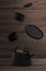 Modern black cast iron teapot with levitation cups, artistic wood background set, art set for tea time. 3d rendering