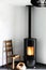 Modern black stove with burning flames and pellet bag in a living room