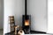 Modern black stove with burning flames and pellet bag in a living room