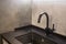 Modern black water tab and square sink with concrete wall