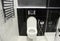 A modern black and white toilet, bathroom with a wall mounted toilet bowl, bidet shower, bidet sprayer and heated towel rails,