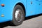Modern blue bus on road, focus on wheel.