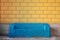 Modern blue metal sofa against yellow tile wall/ Urban furniture