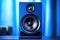 Modern blue powerful audio speaker on yellow background, space for text