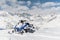 Modern blue snowmobile on the background of snow mountains