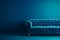 Modern blue sofa couch against a plain blue wall with copy space