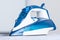 Modern blue steam iron on ironing board