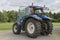 Modern blue tractor on a farmyard