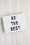 Modern board with `Be the best` words on a white wooden background. Flat lay, overhead, top view, from above