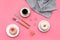 Modern breakfast desing with sweet donut, coffee and flowers on woman pink desk background top view