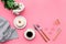 Modern breakfast desing with sweet donut, coffee and flowers on woman pink desk background top view mock up