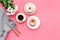 Modern breakfast desing with sweet donut, coffee and flowers on woman pink desk background top view mock up