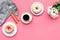 Modern breakfast desing with sweet donut, coffee and flowers on woman pink desk background top view mock up