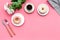 Modern breakfast desing with sweet donut, coffee and flowers on woman pink desk background top view mock up