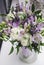 Modern bride bouquet of violet fresia, buttercup ranunculus peonies, green leaf, lilac lavender, roses, rosemary in