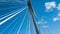 Modern bridge pylon against a blue sky. Detail of a multi-span cable-stayed bridge. White cable-stayed suspension bridge