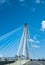 Modern bridge pylon against a blue sky. Detail of a multi-span cable-stayed bridge. White cable-stayed suspension bridge