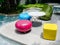 Modern bright colors chairs and a variety of shapes and round tables beside the outdoor swimming pool