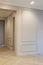 Modern and bright interior of empty cream colored corridor with herringbone parquet floor