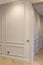 Modern and bright interior of empty cream colored corridor with herringbone parquet floor