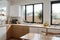 Modern bright kitchen interior with white horizontal window blinds, wooden cabinets with white countertop and household appliances