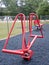 A modern bright red seesaw for two people of equal weight at playground